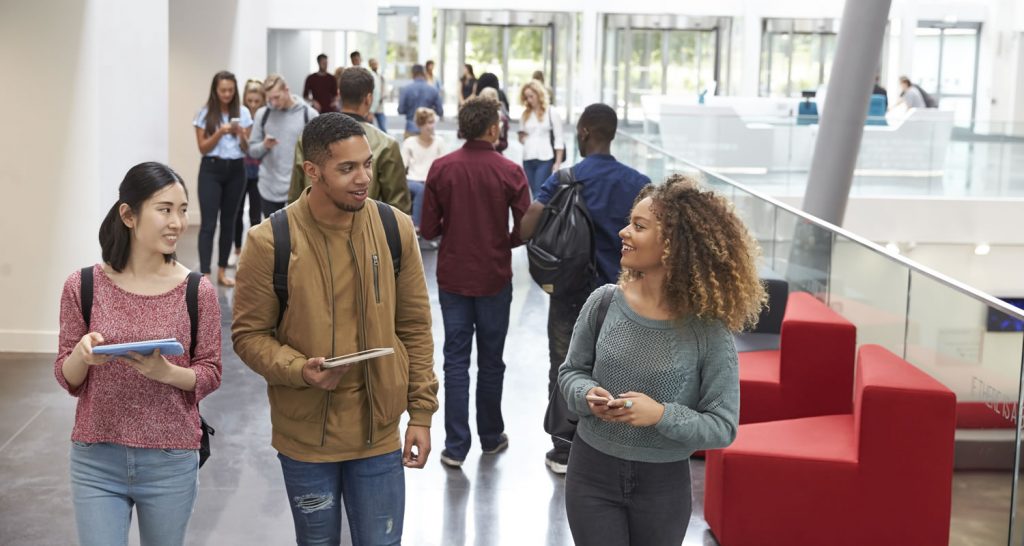 Students walking and talking in a busy university atrium