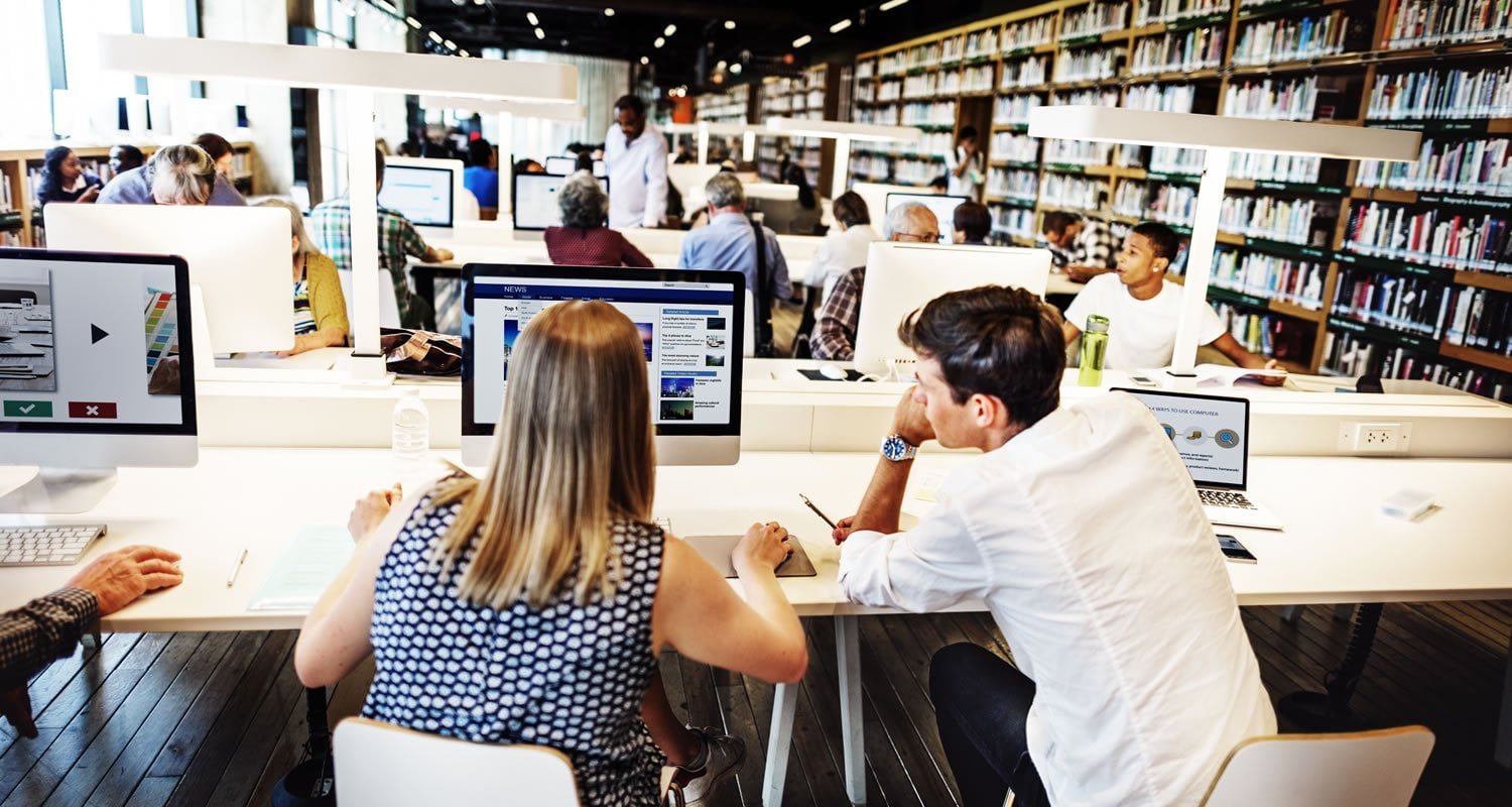 Students working at computers in a large modern library